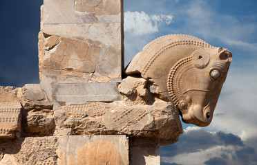 Bull Figure from Achaemenid Dynasty as a Column Capital in Persepolis of Iran Against Cloudy Blue Sky