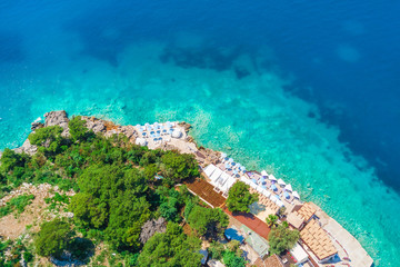 Rocky beach with sun beds, top view