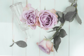 Floral arrangement. Antique pink roses on white wooden background