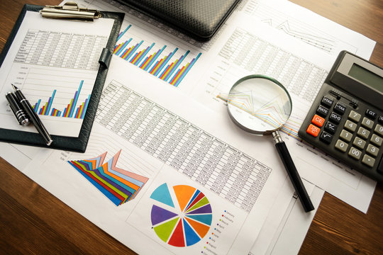 Financial printed paper charts, graphs,calculations, calculator
 and diagrams