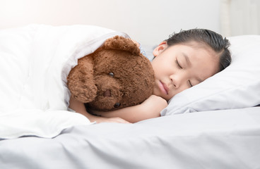 cute little asian girl sleep and hug teddy bear