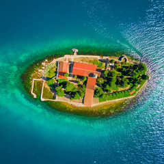 Top view of the island with a monastery in the blue sea