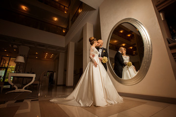 beautiful blonde bride with bridegroom at the mirror
