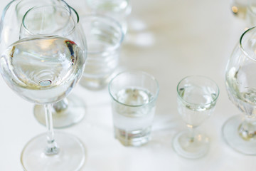 Close-up of glasses of crystal clear drinking water on a white table. Shallow depth of focus. Health concept from nature.