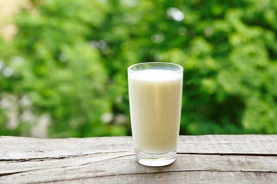 A glass of fresh milk on a wooden table