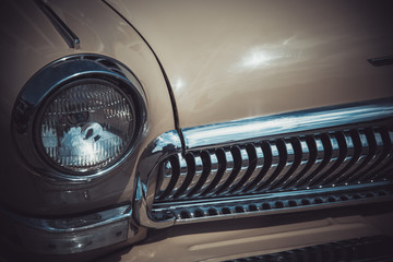 Headlights and body of an old classic car at an exhibition of vintage cars