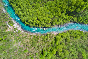 Top view of the river in the mountains surrounded by a green forest