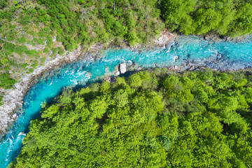Top view of the river in the mountains surrounded by a green forest