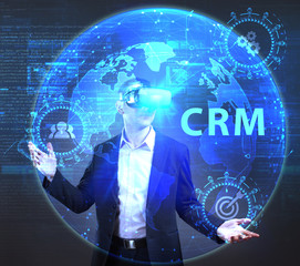 The concept of business, technology, the Internet and the network. A young entrepreneur working on a virtual screen of the future and sees the inscription: CRM