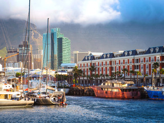 Obraz premium Victoria and Alfred Waterfront ma przepiękne widoki na Ocean Atlantycki, port Table Bay, za chmurami unoszącymi się na Górze Stołowej z ciemnoniebieskim morzem i niebieskim tłem, Kapsztad, RPA