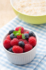 Oatmeal porridge in bowl with berries raspberries and blackberries.