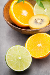 Fototapeta na wymiar Mixed citrus fruit lemons, orange, kiwi, limes on a gray background.