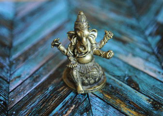 Fototapeta na wymiar Gilded elephant figure of Ganesha on a bright colored parquet background