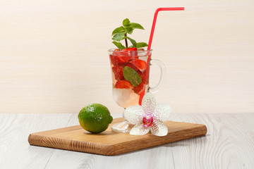 Carbonated lemonade with strawberry slices and mint on an wooden cutting board