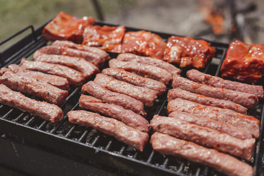 Different type of meats cooked outside, on a hot grill barbecue.