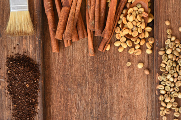 Freshly coffee beans in spoon and  ground coffee beans on table with cinnamon
