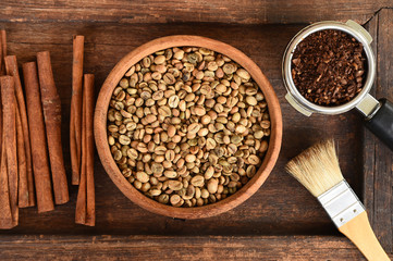 Freshly ground coffee beans in a metal filter and different coffee beans in a square box with coffee beans in bowl