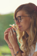Pretty girl smelling plumeria tropical flower.