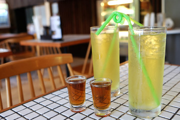 Iced green tea drink with syrup on table in restaurant