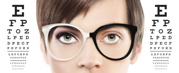 eyes and eyeglasses close up on visual test chart, eyesight and eye examination concept in white...