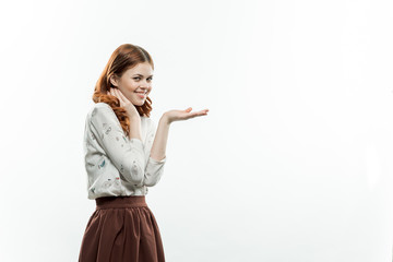 Smiling woman shows her hand free space on a light background