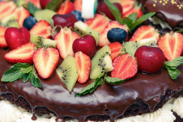 Strawberry, kiwi, cherry, mint, leaves, cream on sweet brown cream