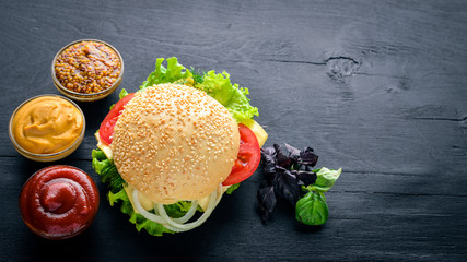 Hamburger with cheese, meat and green onions on Wooden background. Top view. Free space.