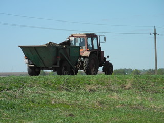 the tractor-trailer in a field on blue sky background