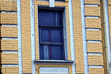 Fototapeta na wymiar старое окно на коричневой кирпичной стене дома