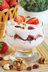 Strawberry yogurt dessert served with various nuts and fresh strawberries