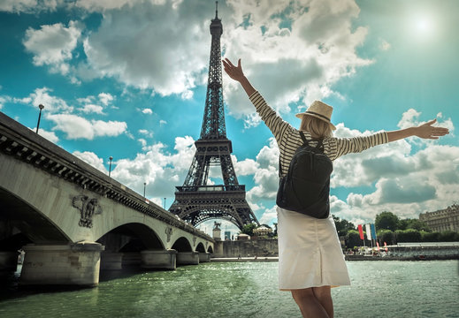 Woman tourist selfie near the Eiffel tower in Paris under sunlig