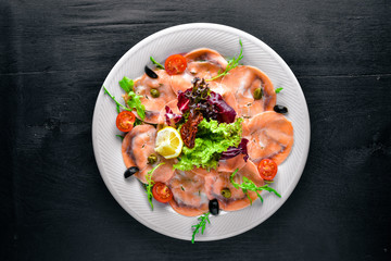 Carpaccio of fish, vegetables, cheese, spices, to Wooden background. Top view. Free space.