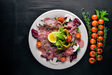 Carpaccio of beef, vegetables, cheese, spices, to Wooden background. Top view. Free space