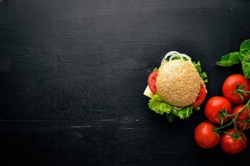 Hamburger with cheese, meat and green onions on Wooden background. Top view. Free space.