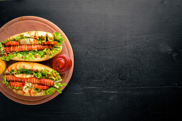 Hot dog with herbs and spices, mustard and ketchup. On Wooden background. Top viewing space.