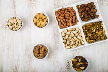 Bowls with nuts on a  wooden table