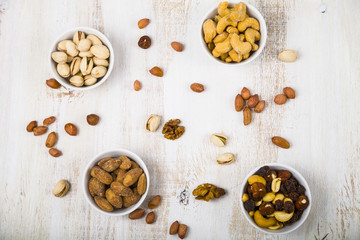 Four bowls with nuts on a  wooden table