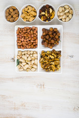 Bowls with nuts on a  wooden table