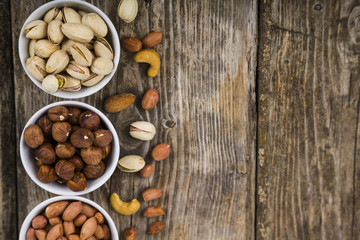 White bowls with nuts on a  wooden table