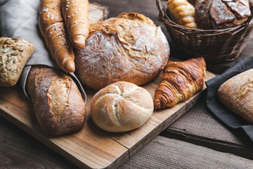 Delicious fresh bread on wooden background