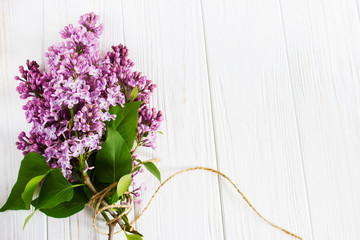 Lilac flowers on the wooden table. Greeting card.