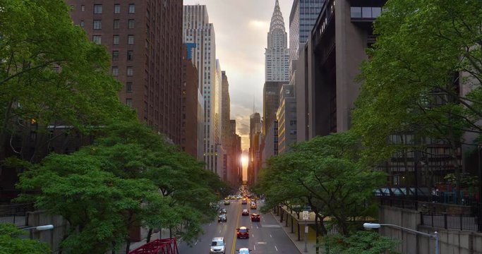 A dramatic wide evening establishing shot over 42nd Street in New York City during "Manhattanhenge."  	