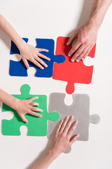 Human hands on colorful puzzle pieces