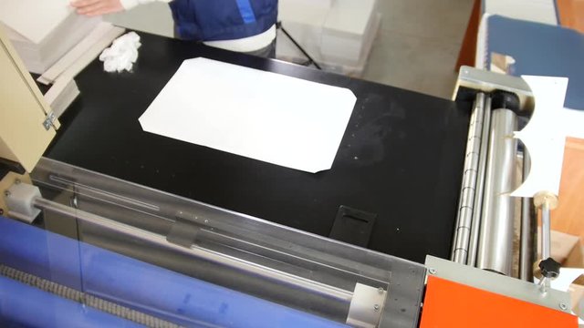 The operator of printing production pulls a printed sheet of paper