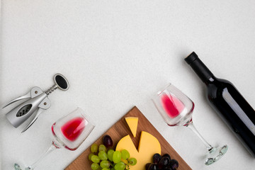 Wine, glasses and corkscrew over white background. Top view