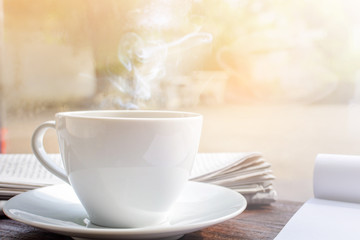 coffee cup clock and news paper on old wooden table nature background