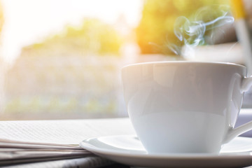 coffee cup clock and news paper on old wooden table nature background