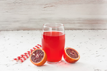 Red bloody orange juice / Glass fresh juice drink and red bloody Sicilian oranges on white...