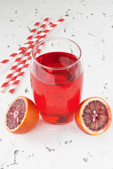 Fototapeta na wymiar Red bloody orange juice / Glass fresh juice drink and red bloody Sicilian oranges on white background