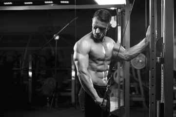 Fototapeta na wymiar Muscular male bodybuilder working out in machine